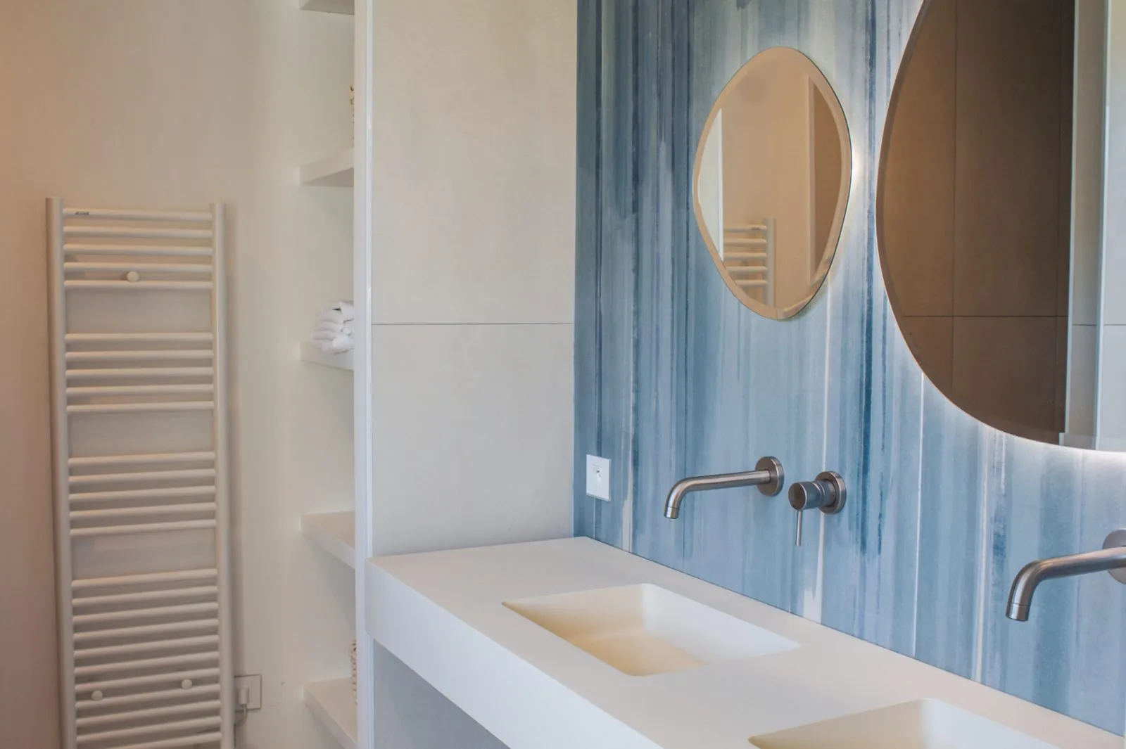 Salle de bain avec double vasque et mur bleu aquarelle.