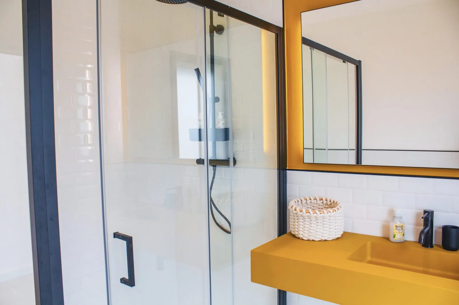 Salle de bain avec vasque jaune et douche a l'italienne.