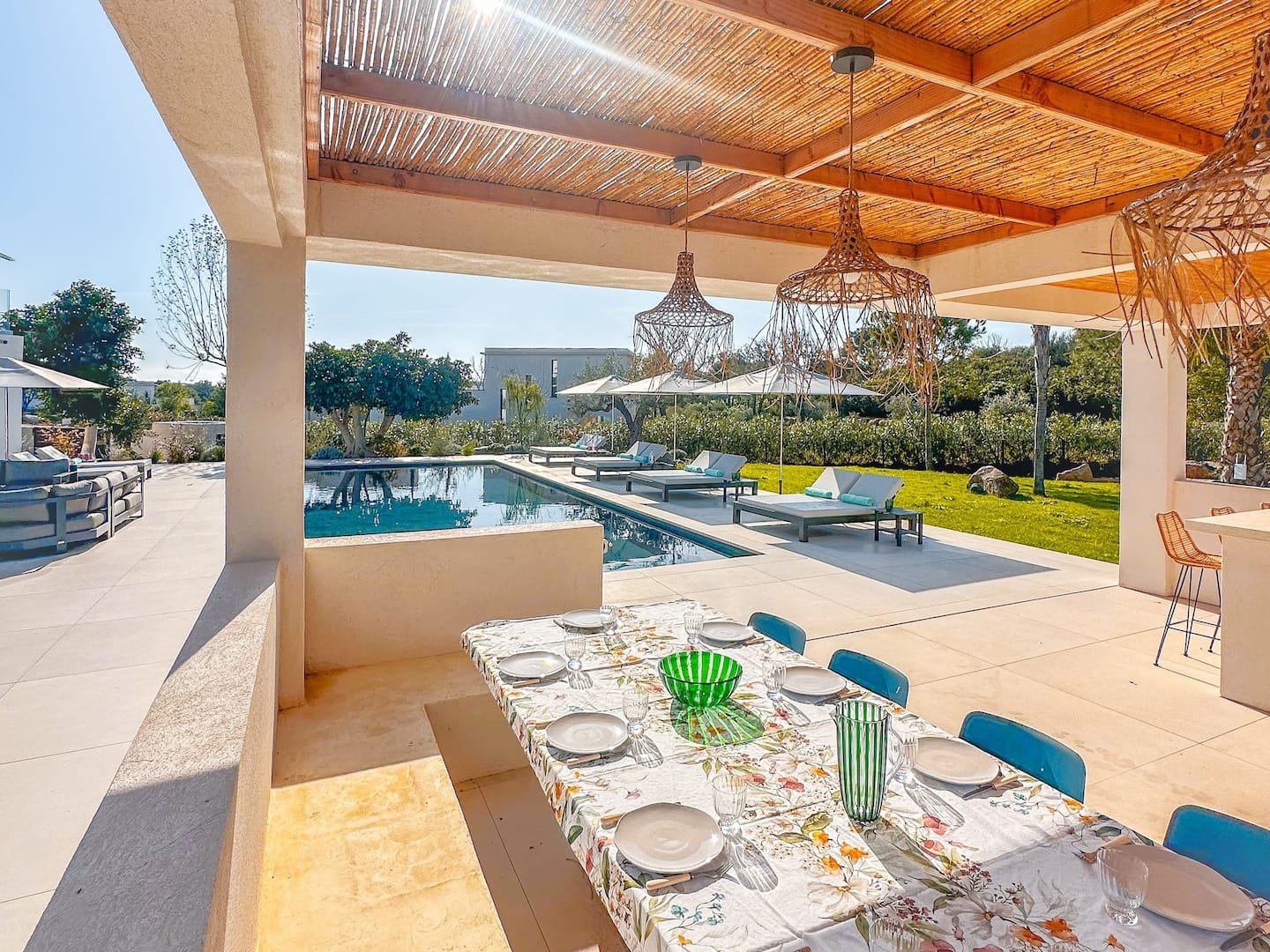 Table exterieure couverte donnant sur la piscine.