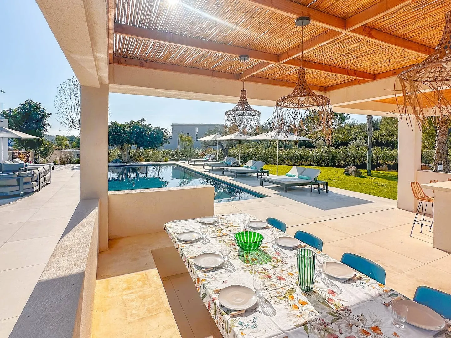 Table exterieure couverte donnant sur la piscine.